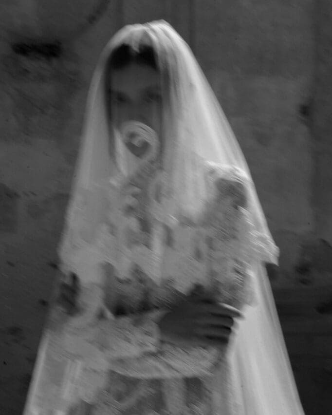 Novia con un velo etéreo en una boda de estilo clásico, representando la intimidad de una celebración bien organizada.