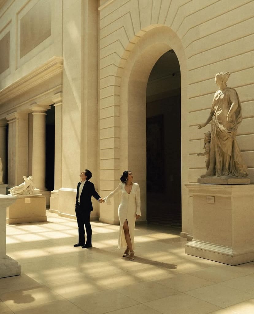 Pareja caminando de la mano en un museo clásico