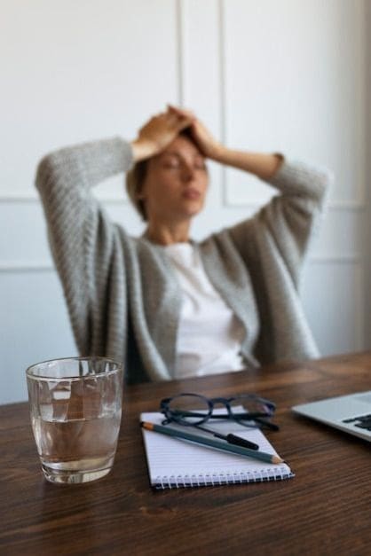 Emprendedora estresada frente a su escritorio, con signos de bloqueo mental.
