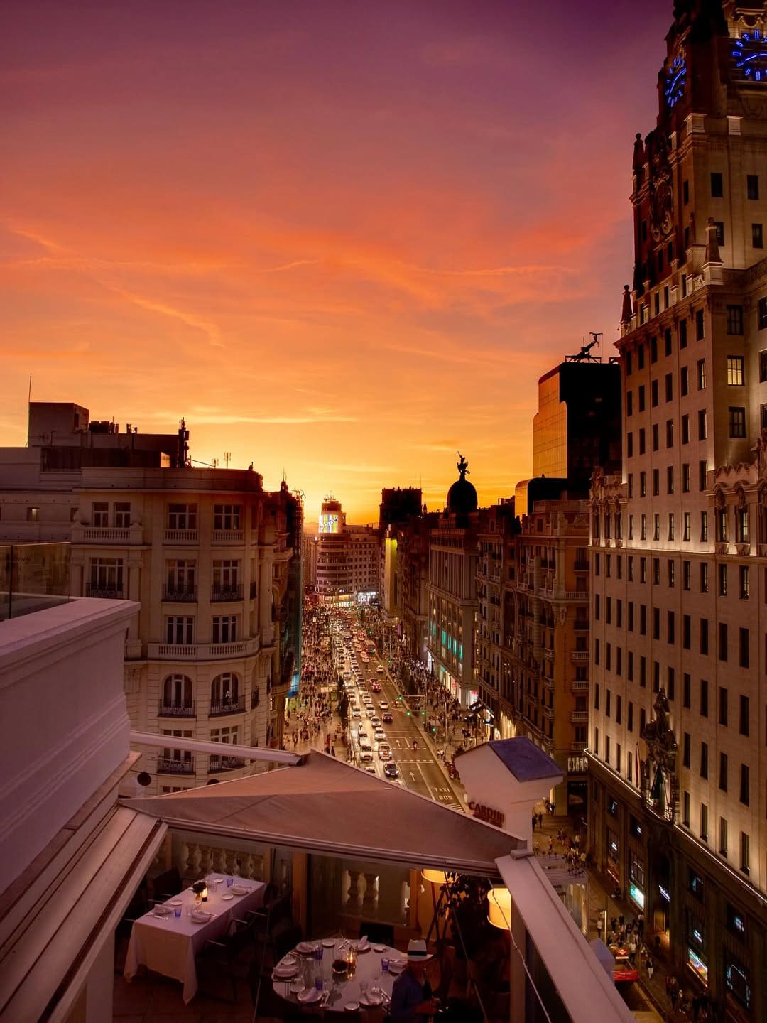 Atardecer sobre la Gran Vía de Madrid desde una terraza elegante